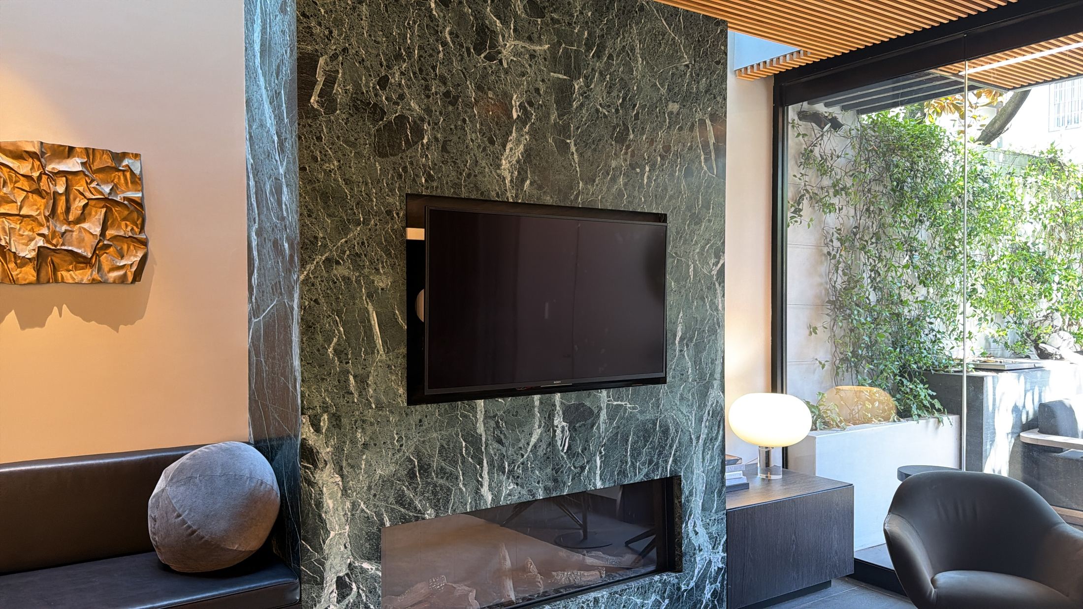 Living room of the Darlinghurst residence with a green marble feature wall and built-in TV