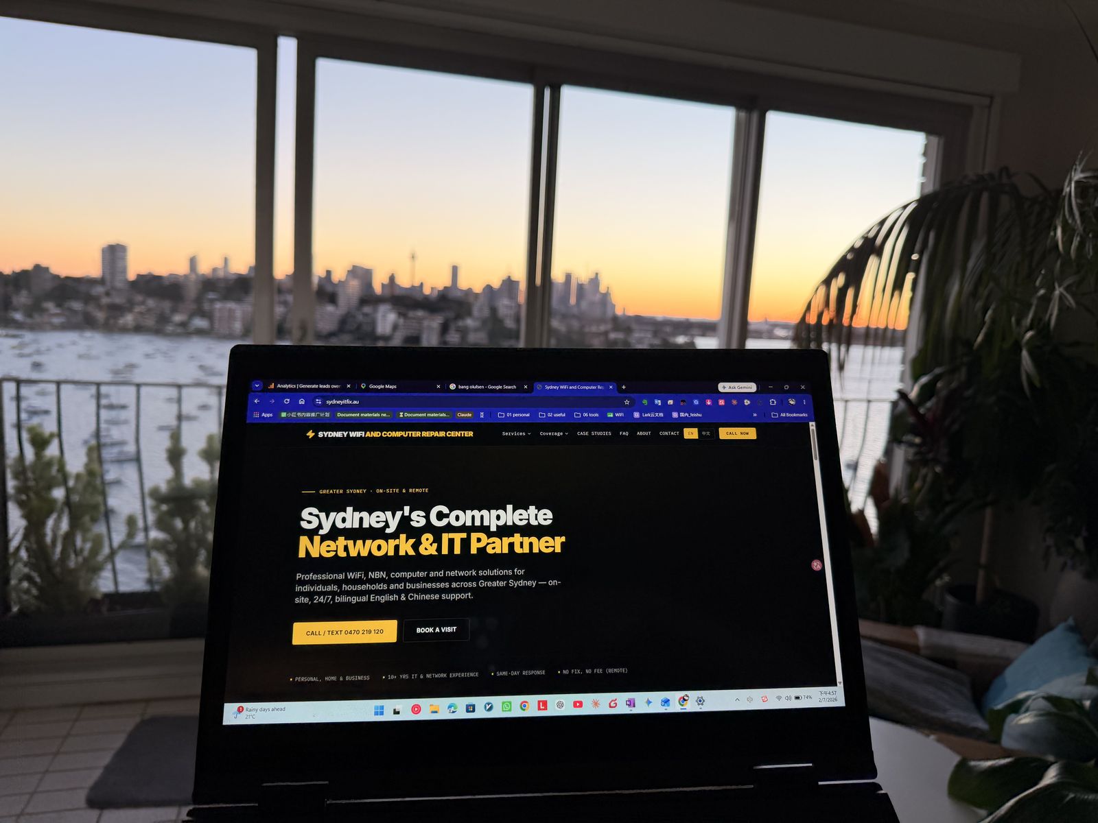 Engineer's laptop by the window with the harbour at sunset